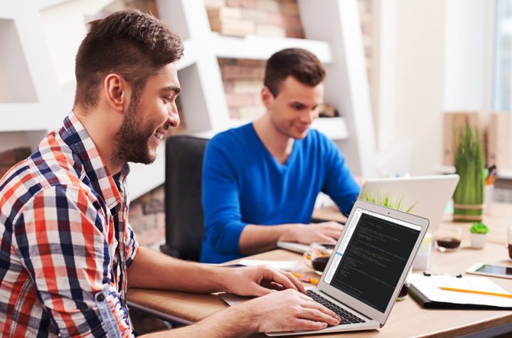 Two men working on laptops.