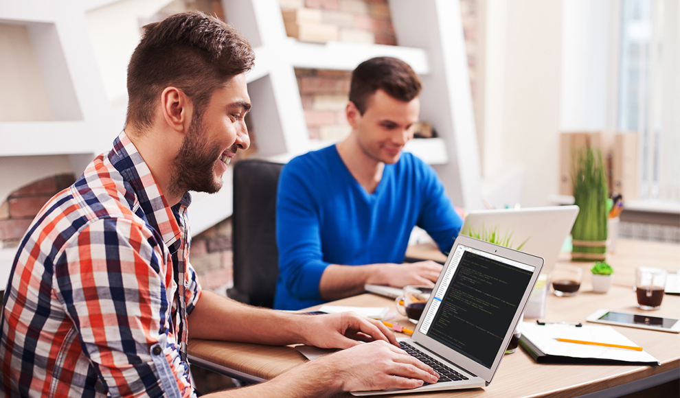 Two men smiling and working