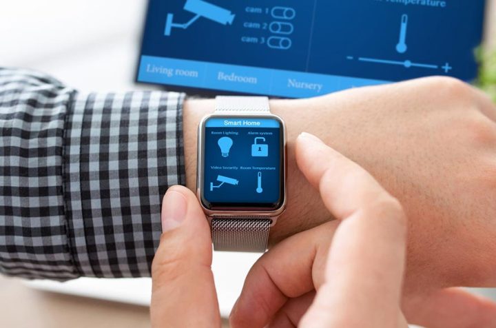 Man using a smartwatch to control a smart home system.