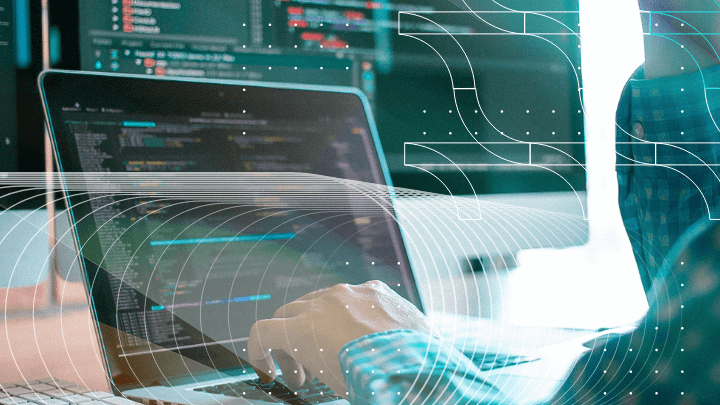 Hands typing on a laptop with code, highlighting programming.