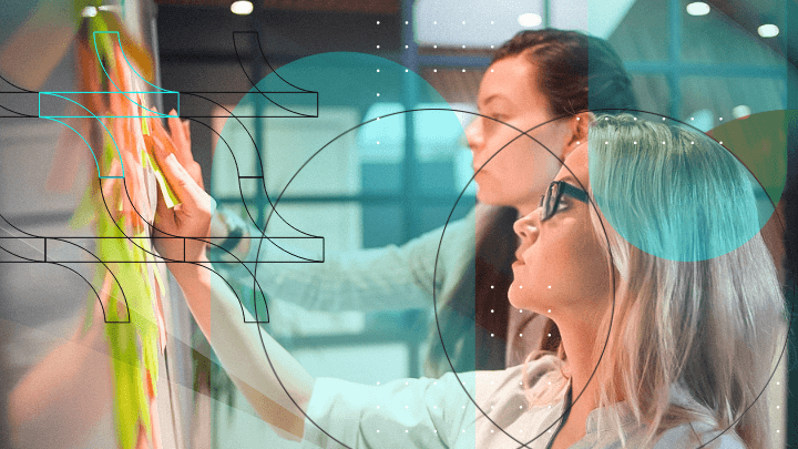 Two women placing sticky notes on a whiteboard, working on a project.
