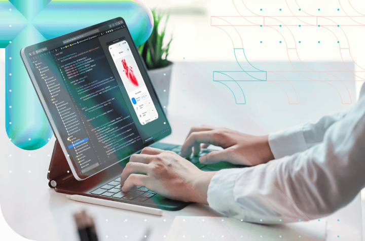 Person typing on a tablet keyboard displaying code and a 3D heart image.