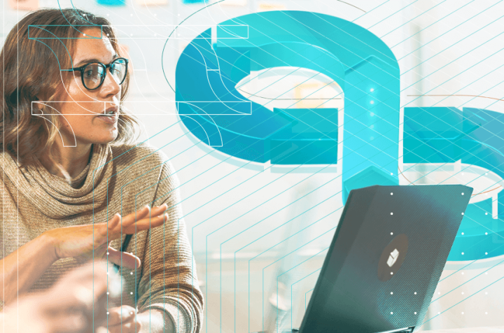 Woman wearing glasses talking in front of a laptop, discussing business concepts.