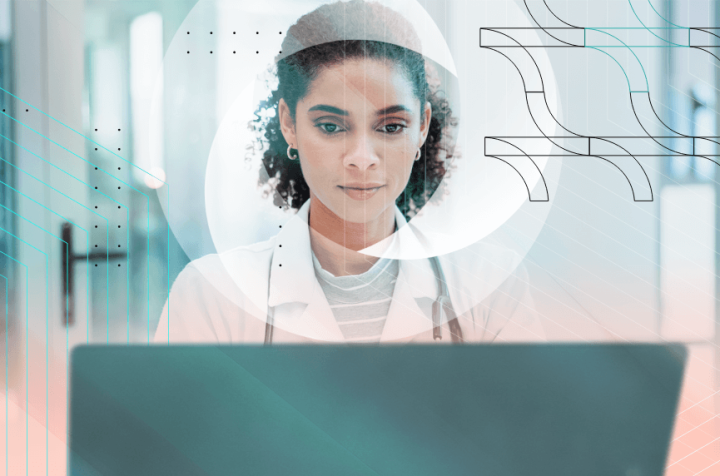 Doctor working on a laptop, focused on the screen.