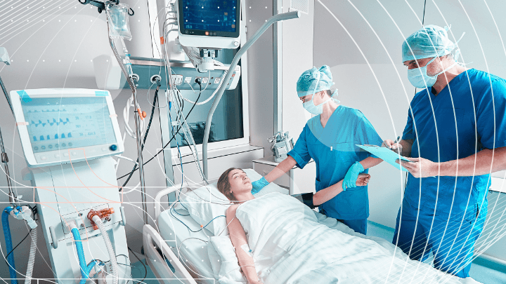 Medical team caring for a patient in an intensive care unit, surrounded by medical equipment.
